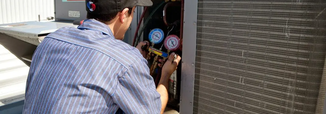 HVAC technician servicing a condenser unit in Rose Hill