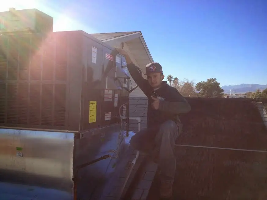 HVAC technician performing Boiler Repair on a rooftop unit in Rose Hill